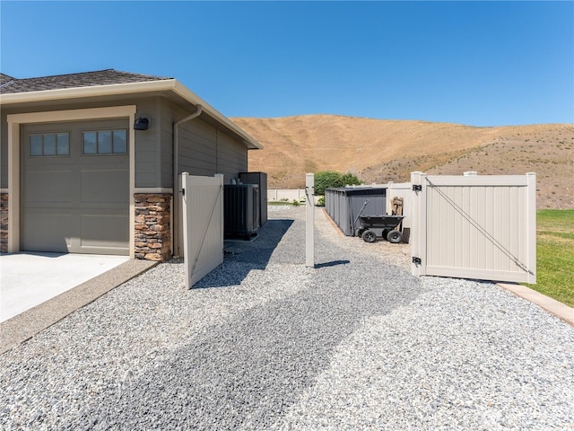 2038 Maiden Ln, Wenatchee, WA 98801 - view of home's exterior with a gate, a mountain view, stone siding, and concrete driveway