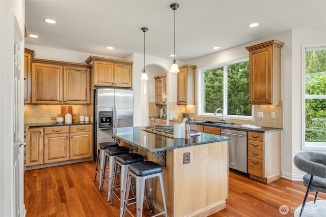 108 239th Way SE, Sammamish, WA 98074 - kitchen with stainless steel appliances, light wood-style flooring, a kitchen island, a kitchen breakfast bar, and tasteful backsplash