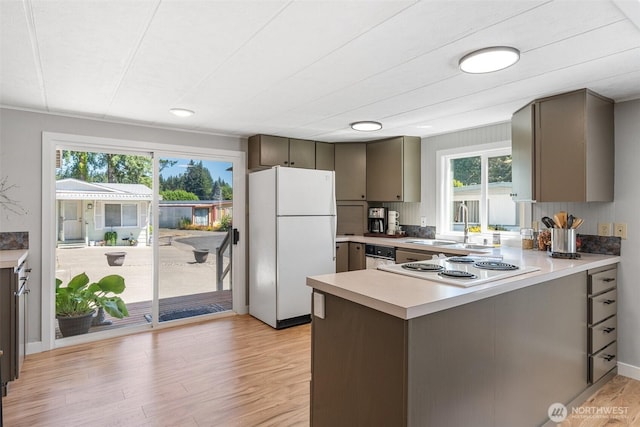 1841 Trosper Rd SW Unit 24, Tumwater, WA 98512 - kitchen with white appliances, light wood-type flooring, a peninsula, light countertops, and gray cabinets