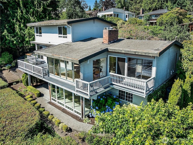 3719 NE 145th St, Seattle, WA 98155 - rear view of house featuring a chimney, a deck, a sunroom, and a shingled roof