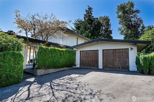 3719 NE 145th St, Seattle, WA 98155 - view of side of home with an outbuilding, a garage, and asphalt driveway