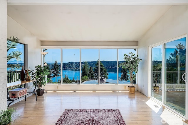 3719 NE 145th St, Seattle, WA 98155 - unfurnished sunroom featuring vaulted ceiling, wood finished floors, and a water view