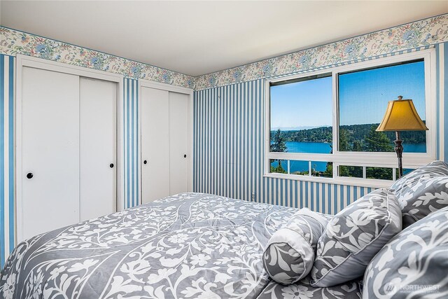 3719 NE 145th St, Seattle, WA 98155 - bedroom with a water view, two closets, and wallpapered walls