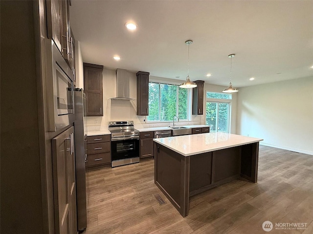 45332 Limestone St, Concrete, WA 98237 - kitchen featuring stainless steel appliances, wall chimney exhaust hood, light countertops, a center island, and dark wood-style flooring