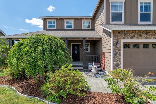 1877 Emerald Way, Lynden, WA 98264 - view of front facade with covered porch, board and batten siding, an attached garage, and stone siding