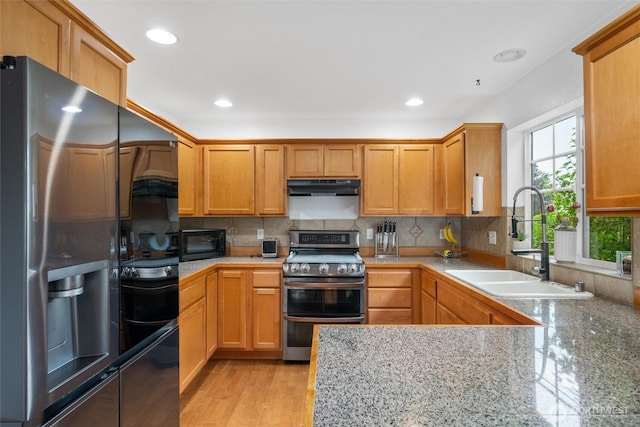 1877 Emerald Way, Lynden, WA 98264 - kitchen with fridge with ice dispenser, double oven range, under cabinet range hood, backsplash, and black microwave