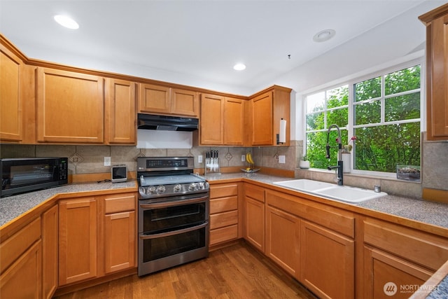 1877 Emerald Way, Lynden, WA 98264 - kitchen featuring double oven range, under cabinet range hood, black microwave, wood finished floors, and decorative backsplash