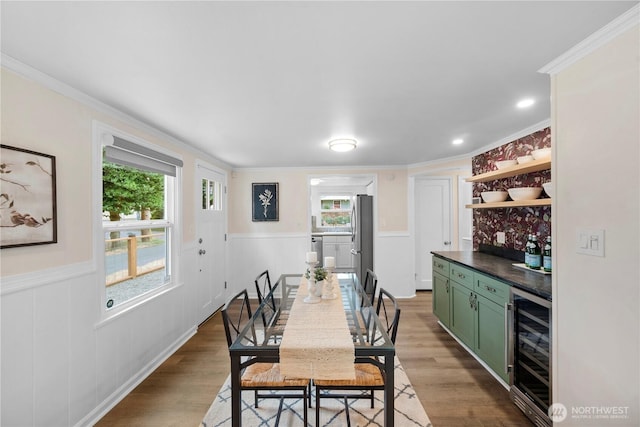 18328 15th Pl NE, Shoreline, WA 98155 - dining room with wine cooler, a bar, wainscoting, wood finished floors, and crown molding