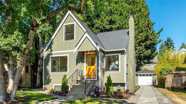 3430 42nd Ave SW, Seattle, WA 98116 - view of front of home featuring board and batten siding, a detached garage, a chimney, an outdoor structure, and concrete driveway