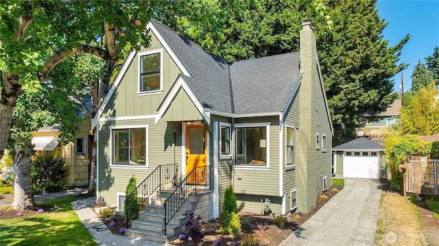 3430 42nd Ave SW, Seattle, WA 98116 - view of front of home with board and batten siding, driveway, a detached garage, an outdoor structure, and roof with shingles