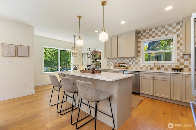 3430 42nd Ave SW, Seattle, WA 98116 - kitchen with dishwasher, light countertops, a breakfast bar, decorative backsplash, and recessed lighting