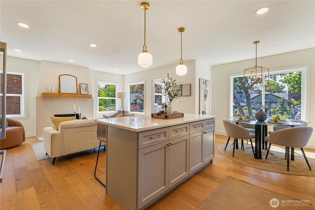 3430 42nd Ave SW, Seattle, WA 98116 - kitchen with gray cabinetry, light wood finished floors, a kitchen island, healthy amount of natural light, and recessed lighting
