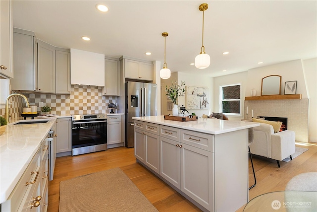 3430 42nd Ave SW, Seattle, WA 98116 - kitchen with appliances with stainless steel finishes, gray cabinetry, backsplash, a kitchen island, and recessed lighting