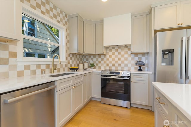 3430 42nd Ave SW, Seattle, WA 98116 - kitchen with appliances with stainless steel finishes, light countertops, tasteful backsplash, and light wood-style floors