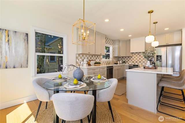 3430 42nd Ave SW, Seattle, WA 98116 - kitchen with appliances with stainless steel finishes, light countertops, decorative backsplash, light wood-style flooring, and recessed lighting