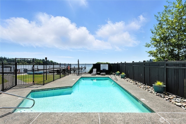 9717 NE Juanita Dr Unit 101, Kirkland, WA 98034 - view of swimming pool featuring a water view, a fenced backyard, and a patio area