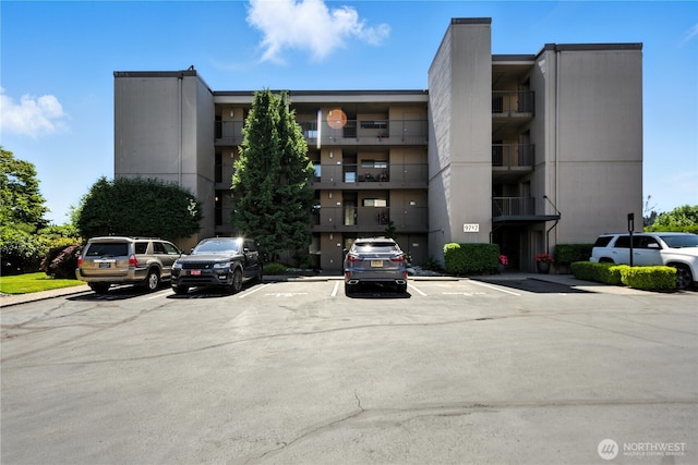 9717 NE Juanita Dr Unit 101, Kirkland, WA 98034 - view of apartment building / complex featuring uncovered parking