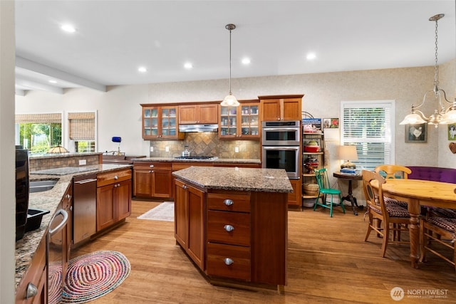 3319 Sunny Cove Ct, Bellingham, WA 98226 - kitchen with stainless steel appliances, brown cabinets, a center island, a chandelier, and light wood-type flooring
