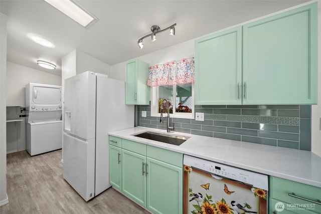 1809 Heritage Hvn, Wenatchee, WA 98801 - kitchen featuring white appliances, stacked washer / drying machine, tasteful backsplash, light wood-style floors, and green cabinets