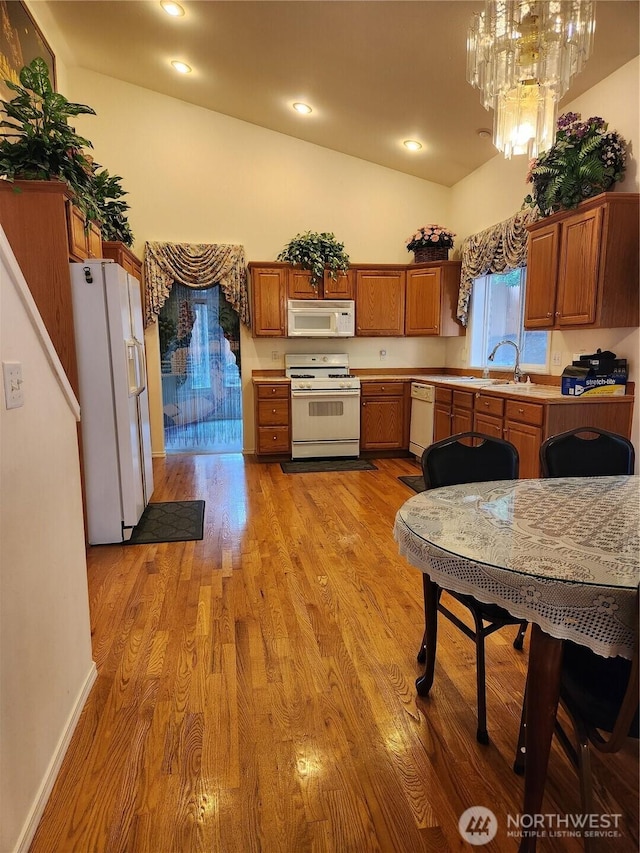 22528 100th Ave SE, Kent, WA 98031 - kitchen featuring white appliances, light wood-style flooring, vaulted ceiling, a chandelier, and light countertops
