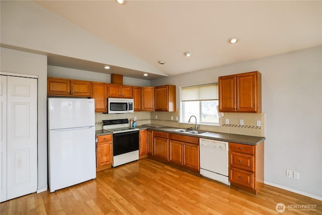 1488 Ocean Shores Blvd SW, Ocean Shores, WA 98569 - kitchen featuring white appliances, dark countertops, brown cabinets, lofted ceiling, and recessed lighting