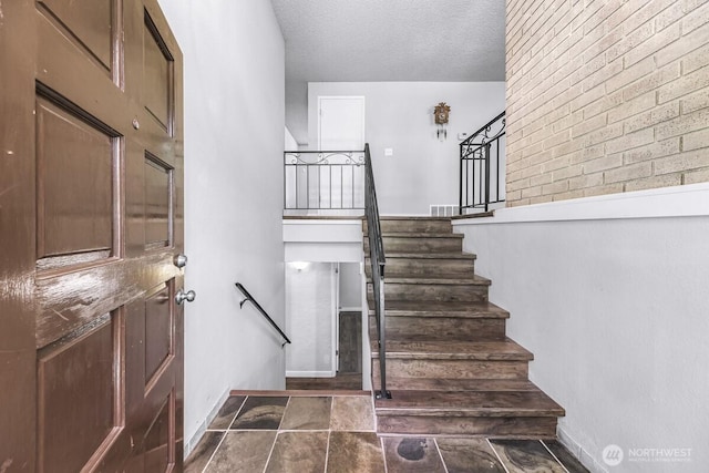 4402 Clearwater Dr SE, Lacey, WA 98503 - staircase with a textured ceiling and stone finish floors