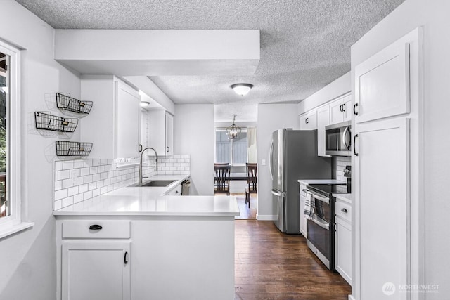 4402 Clearwater Dr SE, Lacey, WA 98503 - kitchen with stainless steel appliances, a textured ceiling, light countertops, white cabinetry, and tasteful backsplash