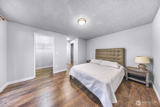 4402 Clearwater Dr SE, Lacey, WA 98503 - bedroom with wood-type flooring, a textured ceiling, and a walk in closet