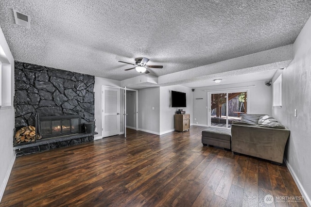 4402 Clearwater Dr SE, Lacey, WA 98503 - living room with wood-type flooring, a ceiling fan, a textured ceiling, and a stone fireplace