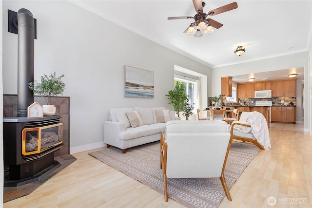 2427 Lincoln St, Bellingham, WA 98225 - living room featuring a wood stove, light wood-style floors, crown molding, and ceiling fan