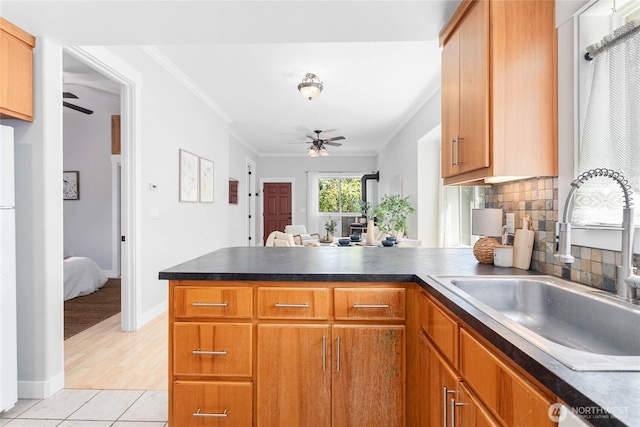 2427 Lincoln St, Bellingham, WA 98225 - kitchen featuring a ceiling fan, a peninsula, crown molding, decorative backsplash, and brown cabinets