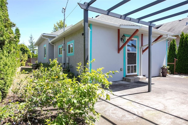 2427 Lincoln St, Bellingham, WA 98225 - view of side of property featuring stucco siding, a pergola, a patio area, and roof with shingles