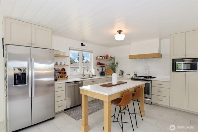 11112 234th St E, Graham, WA 98338 - kitchen featuring appliances with stainless steel finishes, open shelves, custom range hood, light countertops, and backsplash