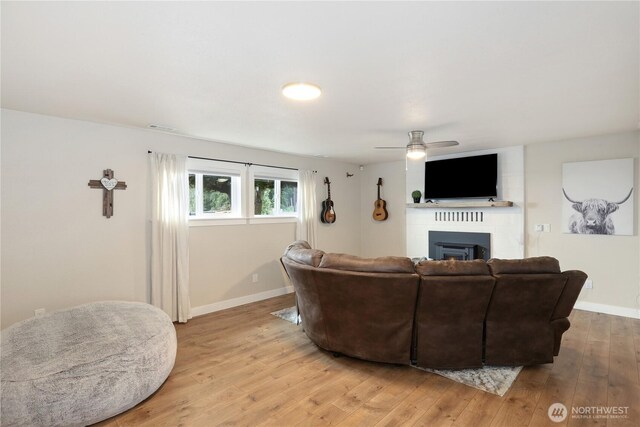11112 234th St E, Graham, WA 98338 - living room featuring a fireplace, ceiling fan, and light wood-style floors