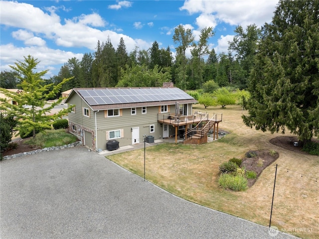 11112 234th St E, Graham, WA 98338 - view of front of property featuring a deck, a garage, stairway, asphalt driveway, and a front yard