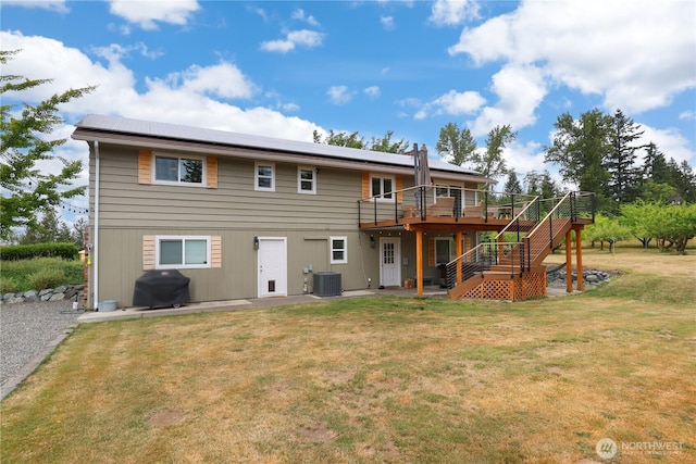 11112 234th St E, Graham, WA 98338 - rear view of property with stairway, a wooden deck, a lawn, roof mounted solar panels, and a patio