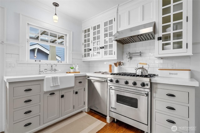 7016 Fremont Ave N, Seattle, WA 98103 - kitchen with appliances with stainless steel finishes, exhaust hood, light countertops, backsplash, and light wood-type flooring