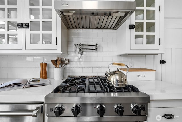 7016 Fremont Ave N, Seattle, WA 98103 - kitchen featuring range hood, stove, decorative backsplash, white cabinets, and glass insert cabinets