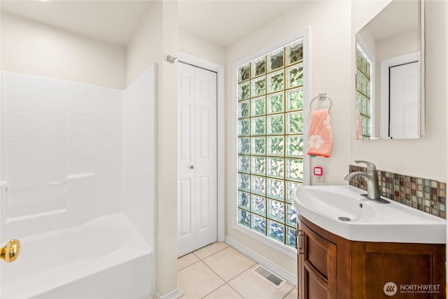 18110 85th St E, Bonney Lake, WA 98391 - bathroom featuring vanity, tile patterned floors, a closet, shower / tub combination, and decorative backsplash
