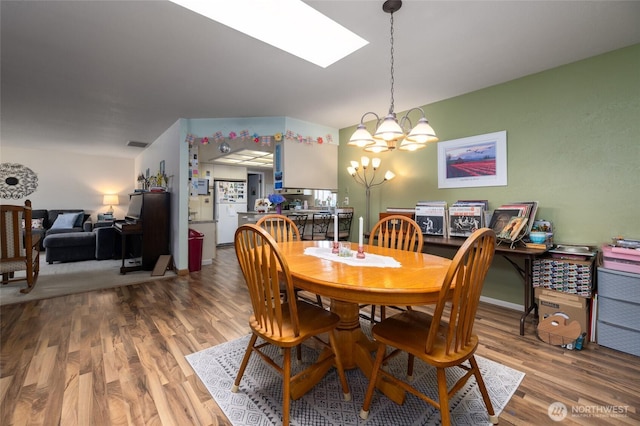 1710 E Highland Ave, Mount Vernon, WA 98273 - dining space with a chandelier, wood finished floors, and a skylight