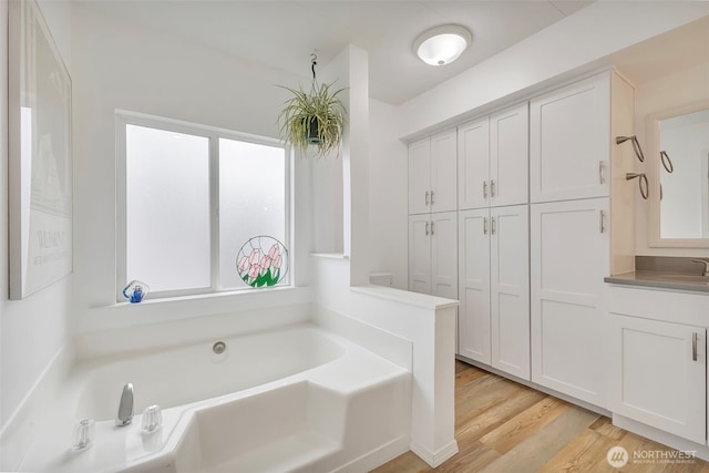 1402 22nd St NE Unit 86, Auburn, WA 98002 - full bathroom featuring plenty of natural light, a garden tub, vanity, and wood finished floors