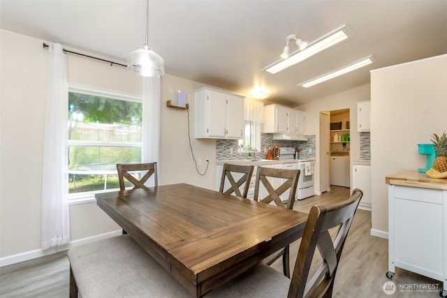 15816 251st St E, Graham, WA 98338 - dining area featuring light wood finished floors, washing machine and dryer, and vaulted ceiling