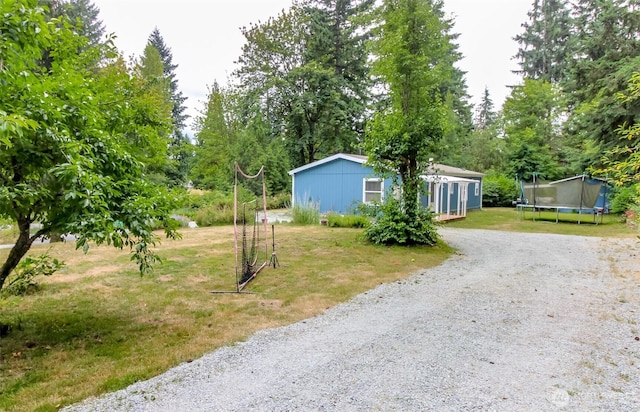 15816 251st St E, Graham, WA 98338 - view of grassy yard featuring a trampoline and gravel driveway