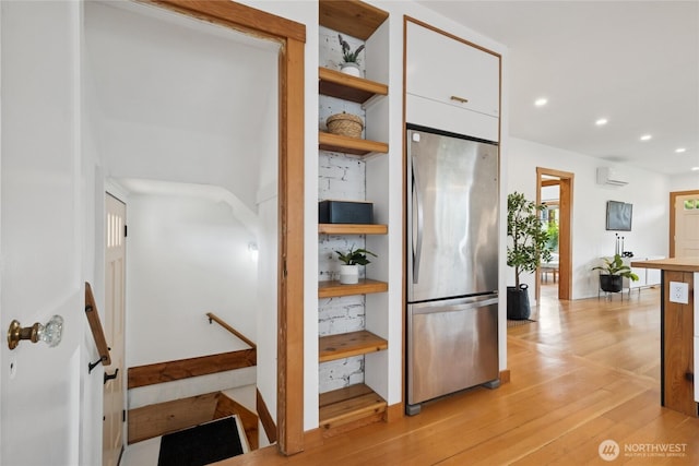 3211 16th Ave S, Seattle, WA 98144 - kitchen featuring freestanding refrigerator, open shelves, a wall unit AC, light wood finished floors, and white cabinetry