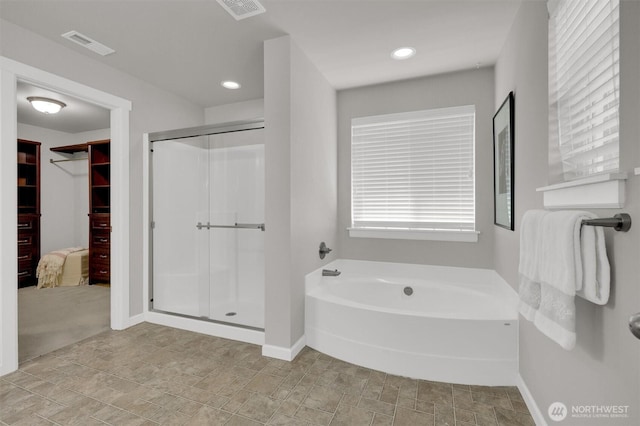 11103 5th Ave SW, Seattle, WA 98146 - bathroom with a stall shower, a bath, a walk in closet, stone finish floors, and recessed lighting