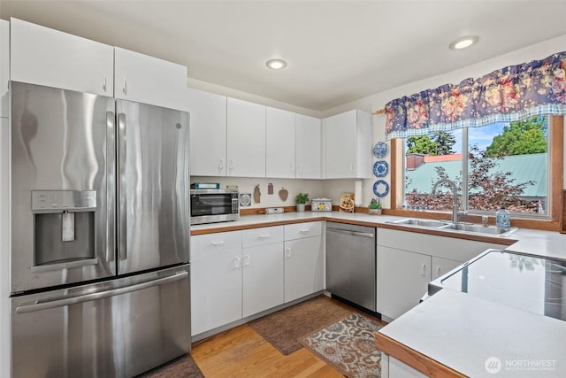 106 River St, Leavenworth, WA 98826 - kitchen featuring stainless steel appliances, light countertops, light wood-type flooring, white cabinetry, and recessed lighting