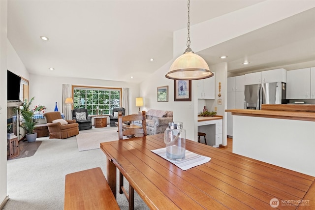 106 River St, Leavenworth, WA 98826 - dining room featuring light carpet, lofted ceiling, recessed lighting, and a glass covered fireplace