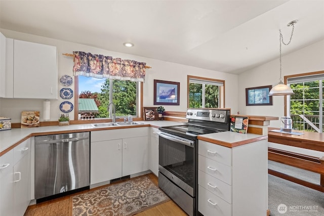 106 River St, Leavenworth, WA 98826 - kitchen featuring stainless steel appliances, a peninsula, light countertops, light wood-style flooring, and white cabinetry