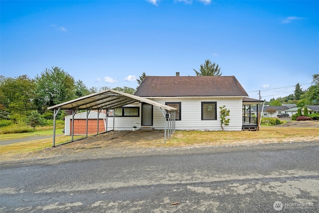 2104 Stuart St, Raymond, WA 98577 - view of front of home featuring asphalt driveway, a detached carport, an outdoor structure, and a shingled roof