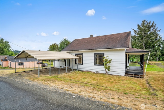 2104 Stuart St, Raymond, WA 98577 - view of front of house with a detached carport, dirt driveway, and a front lawn